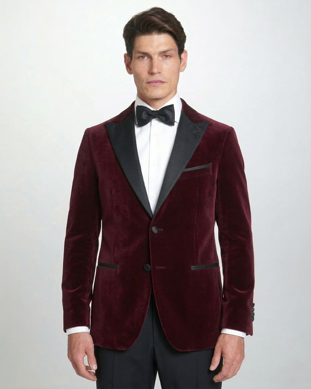 Chaqueta de gala en terciopelo granate con solapa de pico y corte entallado.