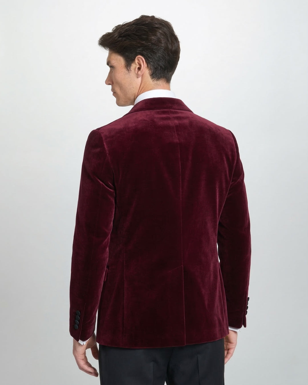 Chaqueta de gala en terciopelo granate con solapa de pico y corte entallado.
